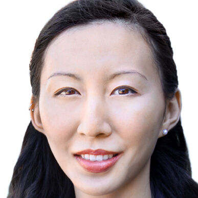 Headshot of a woman in her 20s with heritage from China with light skin tone and long black hair pulled half back; she is wearing a navy blue blazer with a navy blouse and pearl stud earrings; she is smiling at the camera