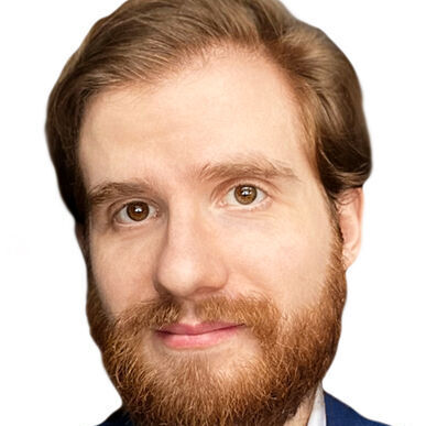 Headshot of a man in his 20s who has heritage from Poland with light skin tone and light red combed hair and red medium length bear. The shot is too zoomed in to see what he is wearing. He is looking at the camera.