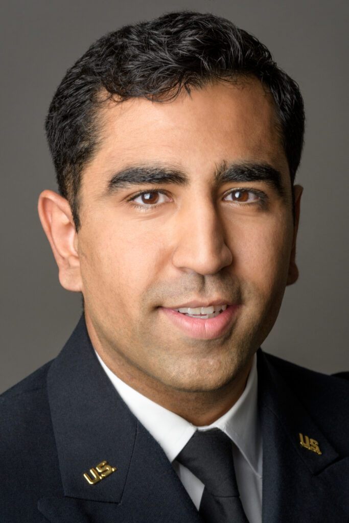 Headshot of a man in his 20s who has heritage from Pakistan with light-medium skin tone and black hair. He is wearing a US Army uniform with brass "U.S" pins on each lapel. He is looking at the camera. 