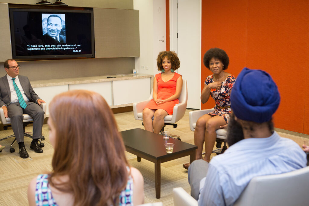 Photograph of people sitting in a circle engaged in discussion.