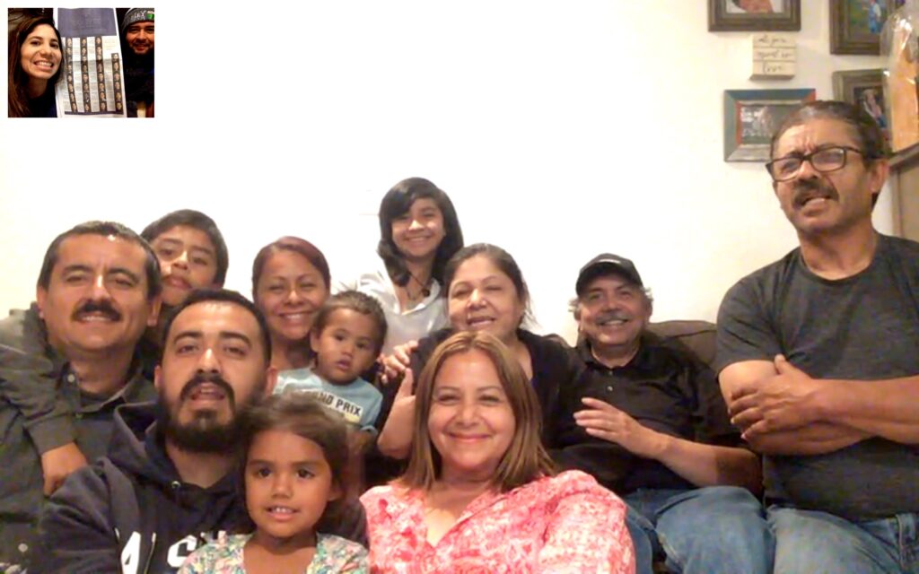 Photograph of a group of people of varying ages, all smiling, they are slightly crammed together in the shot. 