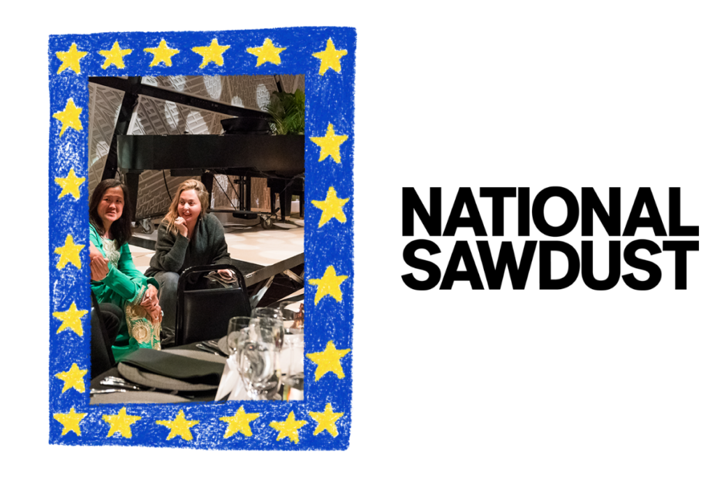 Inside blue crayon style frame with yellow stars: two women of different races sit on a stage in front of a piano looking at someone off camera; next to "National Sawdust" logo in sans serif black font.