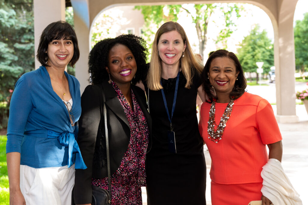 A diverse group of four female Paul & Daisy Soros Fellows posing for the camera at the 20th reunion for the Fellowship in 2018. 