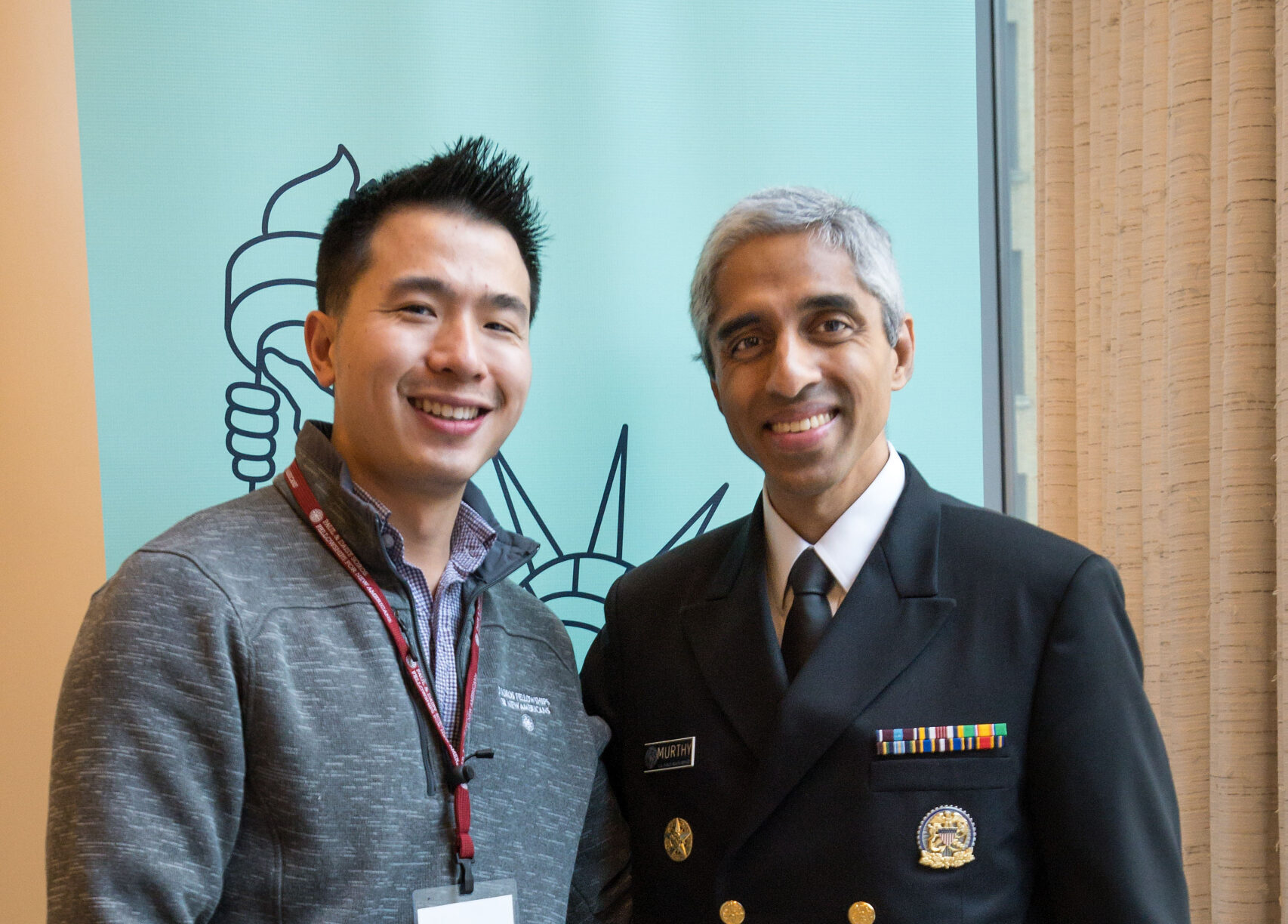 Lawrence Wang and Vivek Murthy stand next to each other at the 2023 Fall Conference with their arms wrapped behind the other.