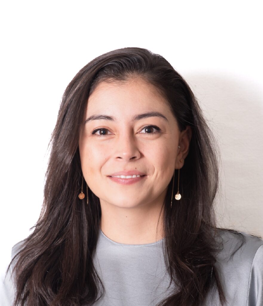 A headshot of Daniela Veloza who has long brown hair and is smiling and looking at the camera.